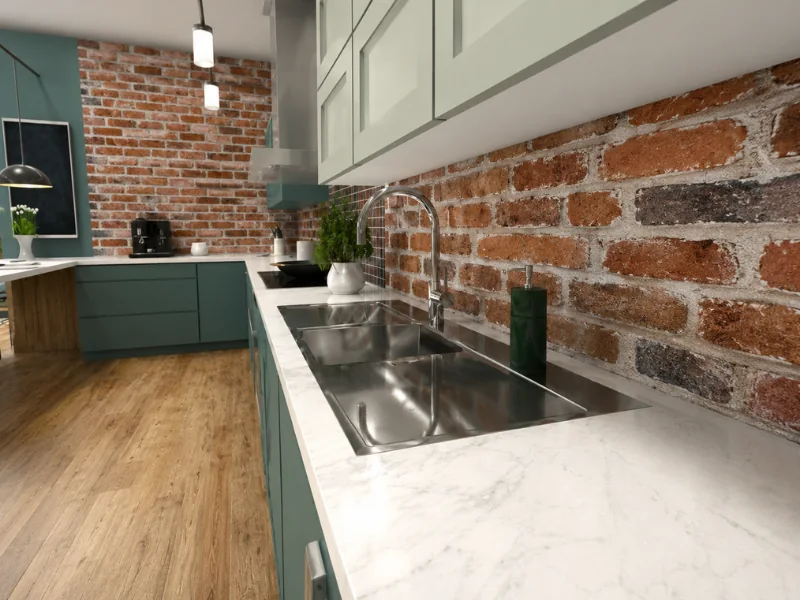 Green kitchen with a stainless steel sink, marble countertop, and exposed brick backsplash.
