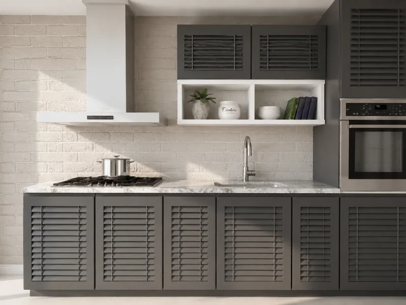 Contemporary dark gray kitchen with louvered cabinets, white brick backsplash, marble countertop, gas cooktop, and built-in oven.