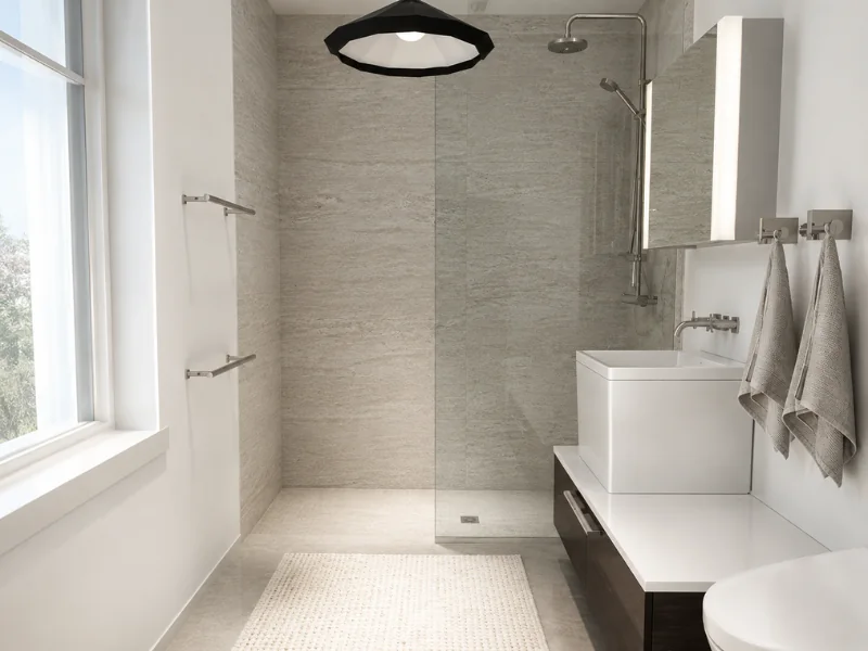 Minimal bathroom with a glass walk-in shower, gray stone tiles, square vessel sink, large window, and wall-mounted mirror.