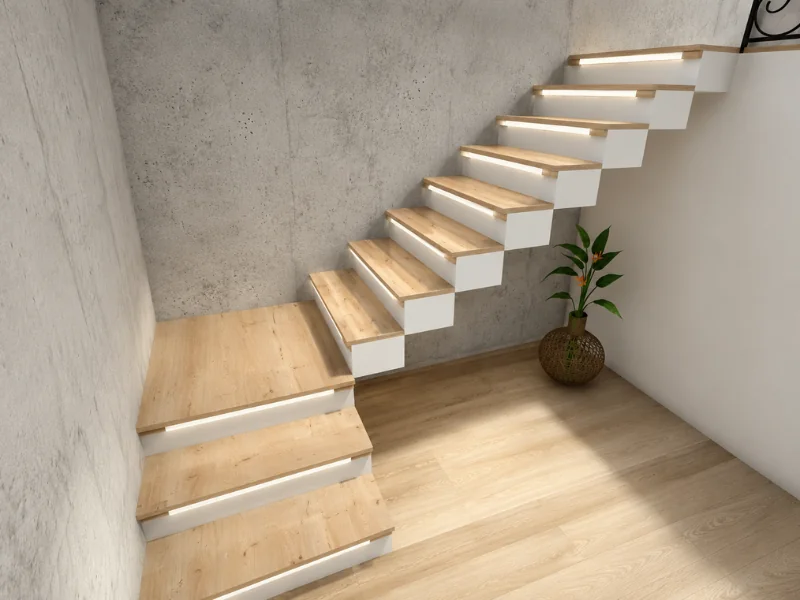 Floating staircase with wood treads, white risers, integrated step lighting, and a concrete wall.