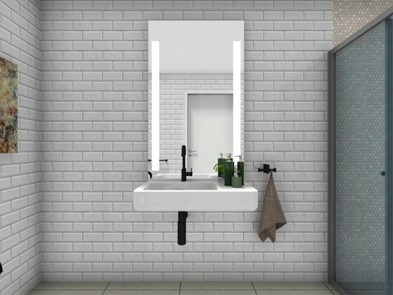 Modern bathroom sink mounted on a tiled wall with clear wheelchair space underneath, featuring a black faucet, soap dispensers on the right, and a towel hanging on the wall, with a mirror and shower visible in the background.