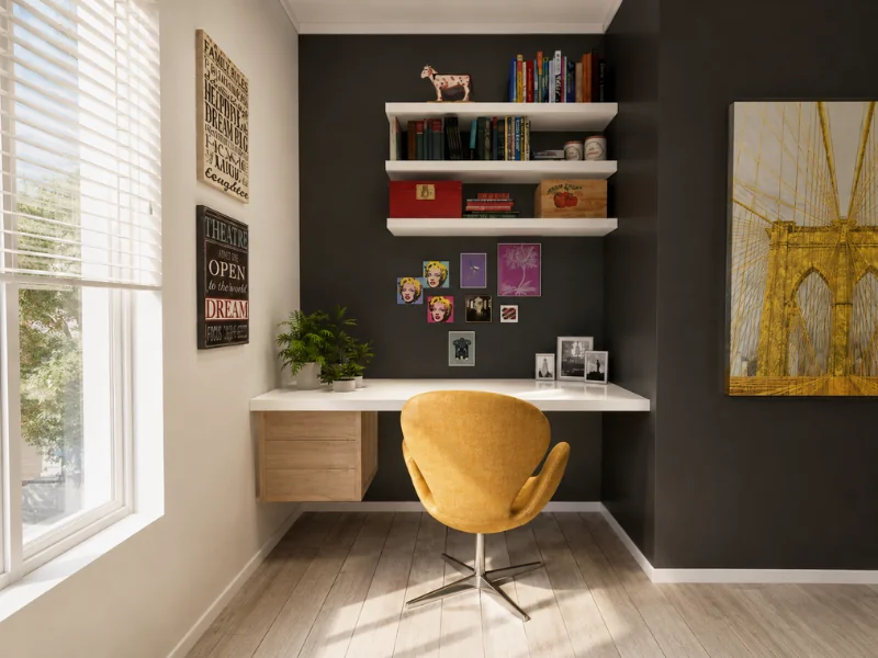 Compact home office with a dark accent wall, floating desk, white shelves, yellow chair, and framed artwork.
