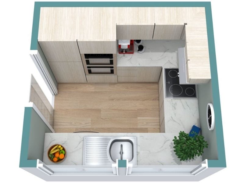 3D floor plan of a compact U-shaped kitchen with light wood cabinets. The sink is centered on the bottom counter, the cooktop is on the right wall, and tall built-in appliances are on the left. The layout shows marble-look counters, wood flooring, and a plant in the corner.