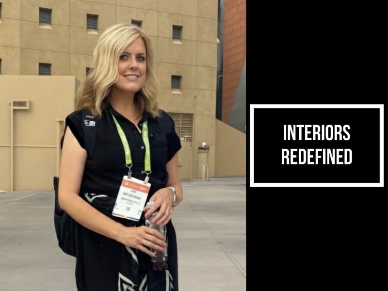 Interior designer Katie Christensen at a design conference, wearing a black outfit and event badge. Text overlay reads “Interiors Redefined.”