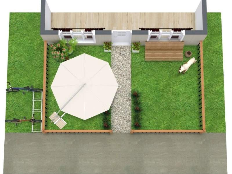 Top-down view of a small fenced backyard with a central gravel path leading to the house, green lawn on both sides, a patio area with a large umbrella and seating, planted garden beds, and a small wooden deck.