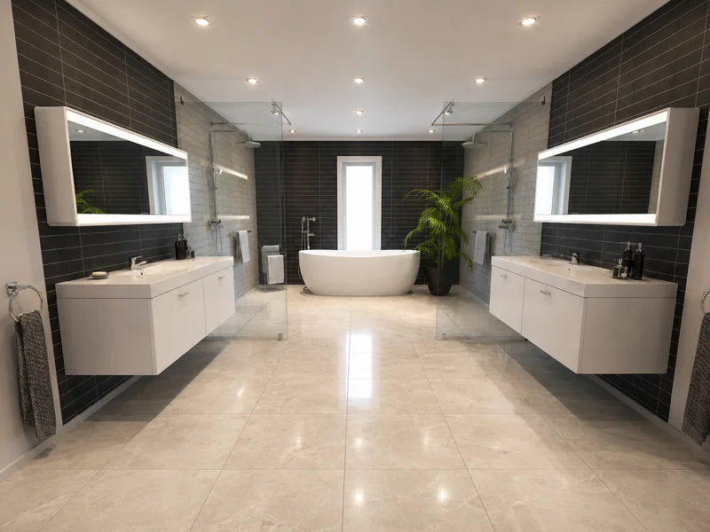 Photorealistic, symmetrical modern bathroom with dark tiled walls, two floating white vanities with illuminated mirrors, glass walk-in showers, and a freestanding bathtub centered beneath a narrow window. A tall green plant adds contrast beside the tub, while warm recessed lighting reflects across the polished light stone floor.