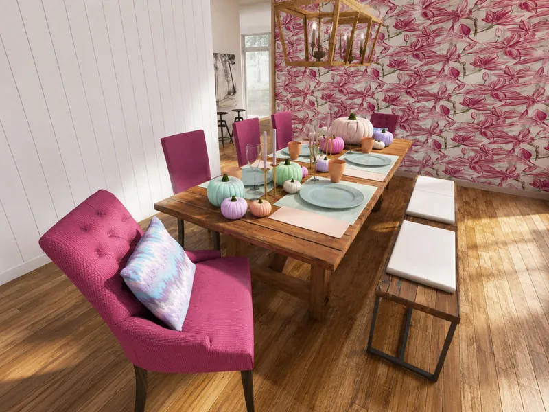 Dining room with a rustic wooden table set with pastel pumpkins, pale blue plates, candles, pink upholstered chairs, bench seating, and bold pink floral wallpaper.
