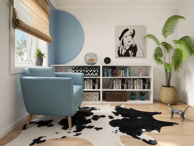 Cozy reading nook with a pale blue armchair, low white bookcase, fishbowl, large potted palm, black-and-white cowhide rug, and graphic portrait art.