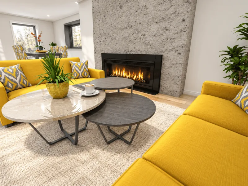 Small living room with yellow sofas, nested coffee tables, and a modern fireplace.