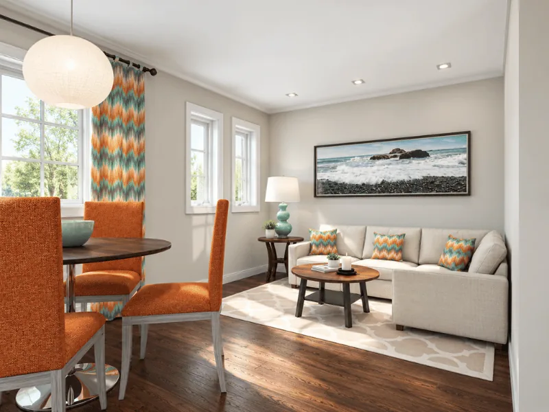 Small living and dining room with a white sofa, orange dining chairs, and colorful patterned accents.