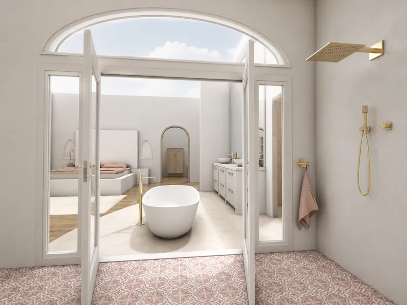 A bright, spa-like bathroom with patterned pink floor tiles, a gold rainfall shower, and open French doors leading to a freestanding white bathtub, double vanity, and adjoining bedroom.