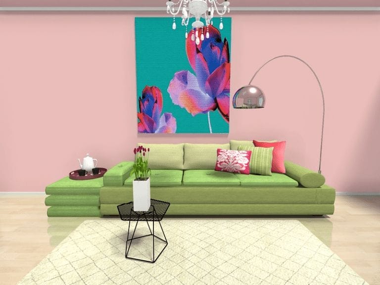 3D rendered image of a vibrant living room with a bold, colorful aesthetic. The room features a light green sectional sofa with pink accent pillows against a soft pink wall. A large, bright floral artwork in teal, purple, and red tones hangs above the sofa. The space is lit by a modern arc floor lamp with a metallic dome shade and a chandelier. A small black wire-frame coffee table with a white vase of tulips sits on a cream-colored textured rug, adding contrast and charm to the playful decor.