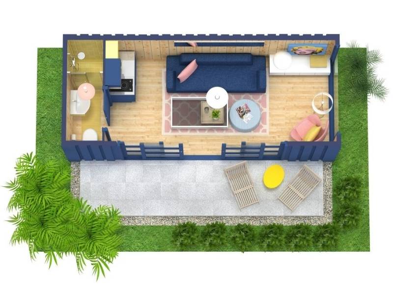 3D floor plan of a small container studio apartment with a bathroom and kitchenette on one side, an open living and sleeping area with sofa, bed, and armchair, plus an outdoor patio with lounge chairs and a table, surrounded by greenery.
