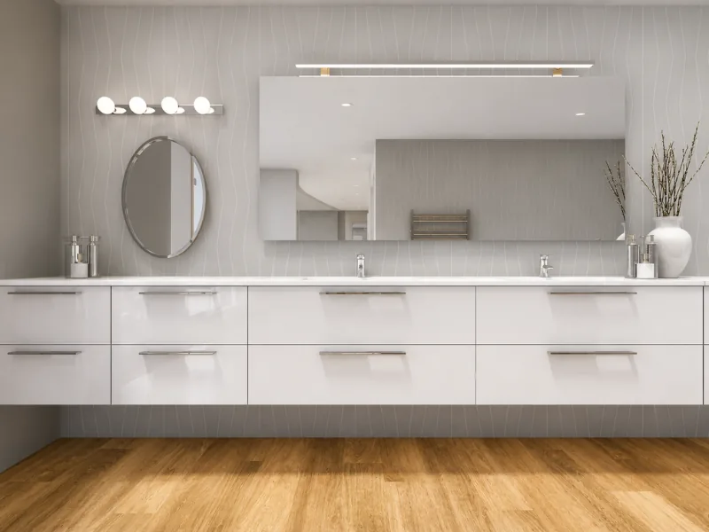 Contemporary bathroom with a long floating double vanity, oversized wall mirror, white drawers, chrome fixtures, soft gray walls, and warm wood flooring.