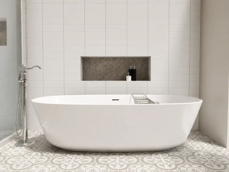 Modern bathroom with a white freestanding tub, patterned floor tiles, white tiled walls, a recessed storage niche, and a chrome floor-mounted faucet.