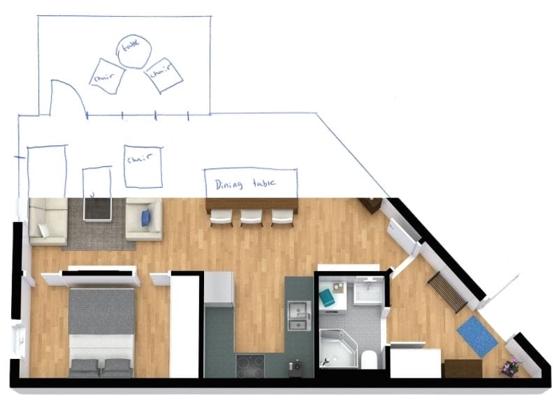 Floor plan image showing a furnished apartment with a hand-drawn extension sketched on top. The 3D-rendered section includes a bedroom, living room, kitchen, bathroom, and hallway, all with wooden floors and modern furniture. Above this, a blue pen sketch outlines a proposed expansion, labeled with items such as “Dining table,” “Chair,” and “Table,” indicating a planned dining or seating area.