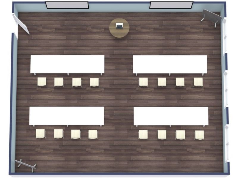 3D floor plan of a rectangular classroom or training room with four long rectangular tables arranged in two rows, each seating four chairs.