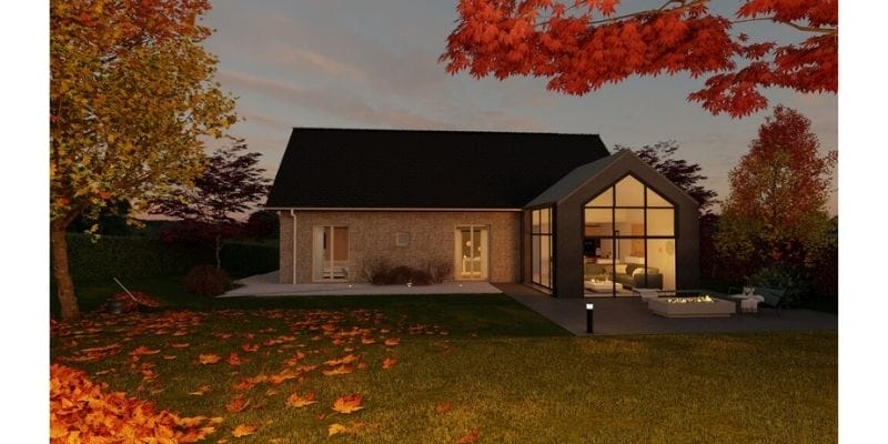 3D photo of a house made with Cedreo. The photo shows the outside of a modern brick house with big windows on the right side of the building. The house has one floor. The site has an outdoor sitting area with a fire pit. There are lights lighting up the site. The image also shows a field of grass and some trees in fall colors, red, orange, and yellow.