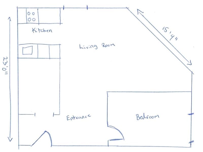 Hand-drawn floor plan sketch showing a simple one-bedroom layout. The plan includes a labeled kitchen area with counters and a stove, an open living room, a separate bedroom, and an entrance area. Approximate dimensions are written: 23 feet 11 inches along the left side and 15 feet 4 inches on a diagonal wall. Walls and fixtures are outlined in blue ink with minimal detail.
