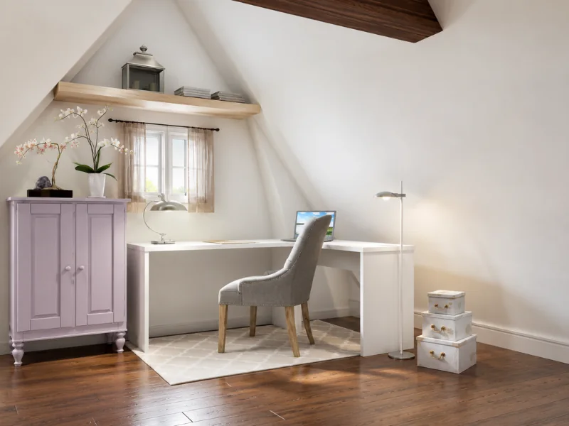 Minimal attic home office with a white corner desk, gray chair, lavender cabinet, wood flooring, and sloped ceiling.