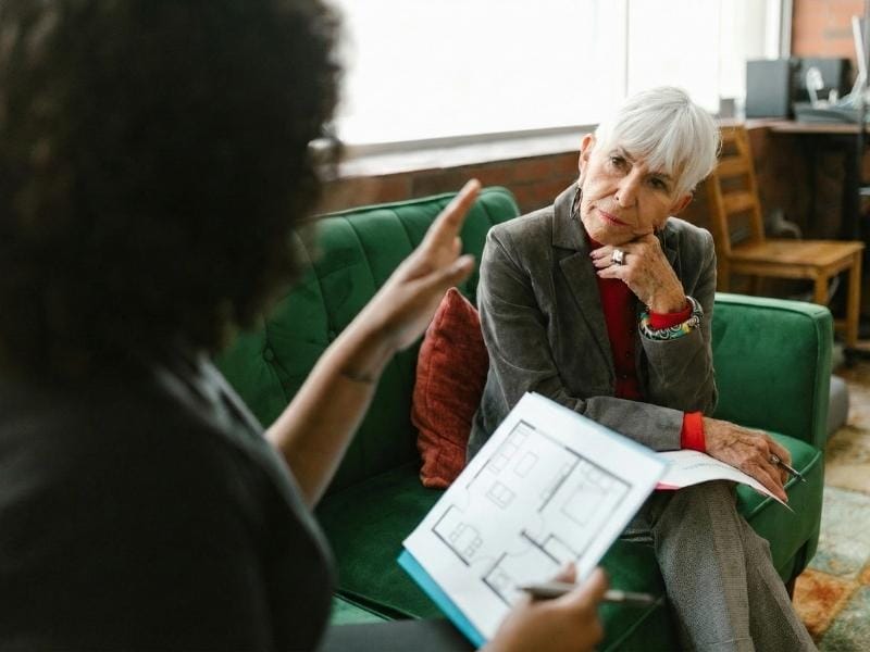 A senior move manager discussing a floor plan with her client.