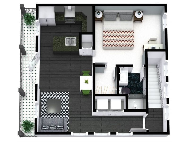 3D rendered floor plan of a one-bedroom apartment. The layout includes a bedroom with a double bed, two nightstands, and a desk. The open-plan living space features a kitchen with an island sink, a dining area with a white table and green chairs, and a living area with a black-and-white patterned rug and gray sofa. The bathroom includes a shower, toilet, and vanity. A stairwell is located near the entrance. The apartment also features a tiled outdoor patio with seating and plants. Dark wood flooring contrasts with white and patterned tiles.