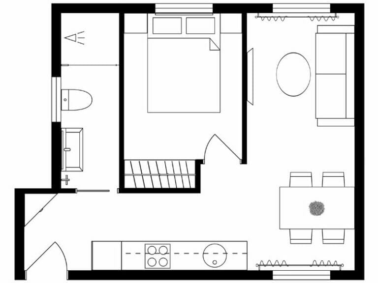 Schwarz-weißer Grundriss einer kleinen Wohnung oder eines Studio-Apartments. Der Entwurf umfasst ein Schlafzimmer mit einem Doppelbett, ein Badezimmer mit Toilette, Waschbecken und Badewanne sowie einen offenen Wohnbereich. Der Wohnraum enthält ein Sofa, einen runden Couchtisch, einen Esstisch mit vier Stühlen und eine Küchenzeile entlang einer Wand mit Herd, Spüle und Arbeitsplatte. Der Eingang befindet sich in der unteren linken Ecke, und eine Treppe ist zwischen dem Schlafzimmer und dem Wohnbereich positioniert. Möbel und Einbauten sind als einfache Strichzeichnungen dargestellt.